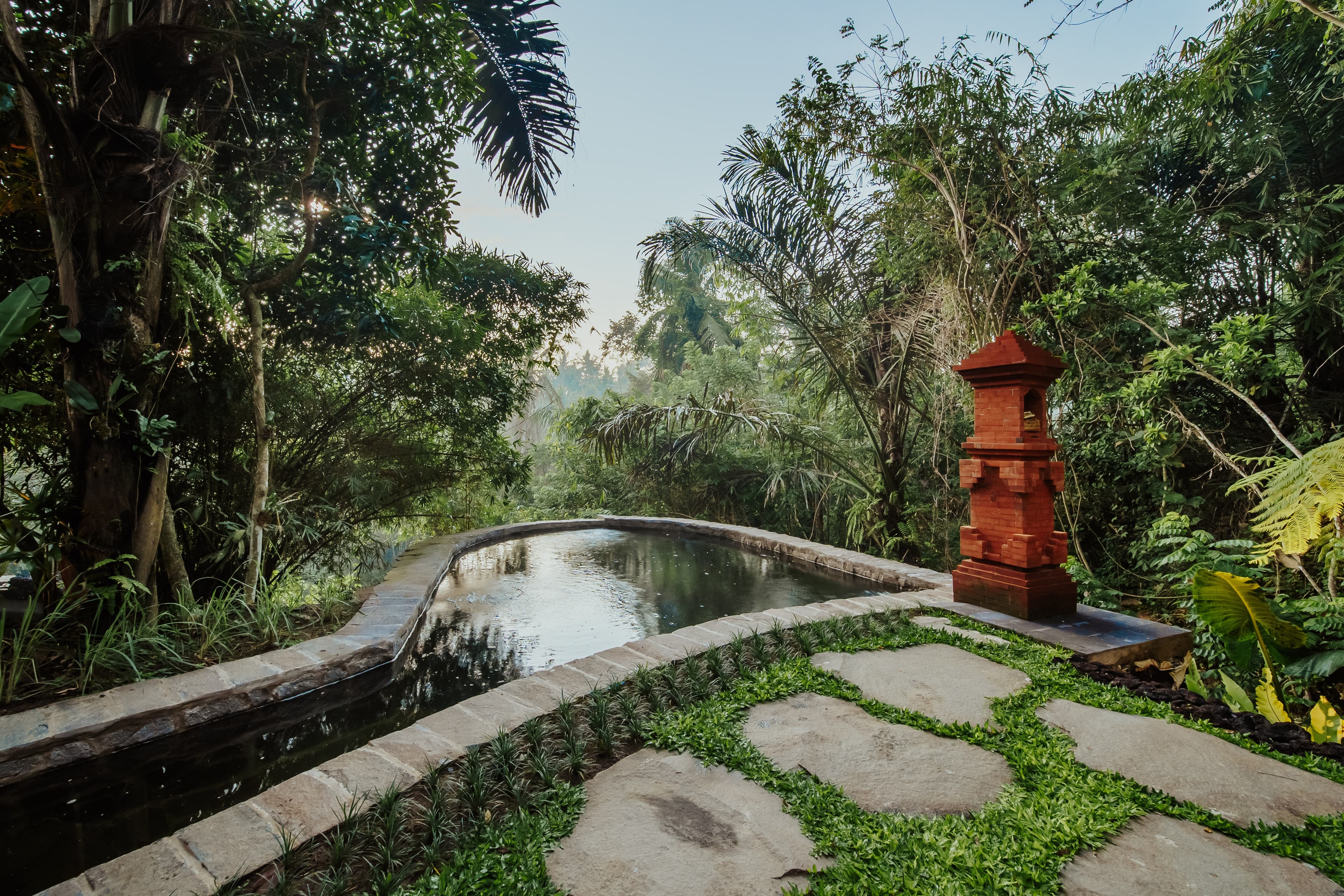 Sungai Villa — riverside natural pool with Balinese shrine and jungle
