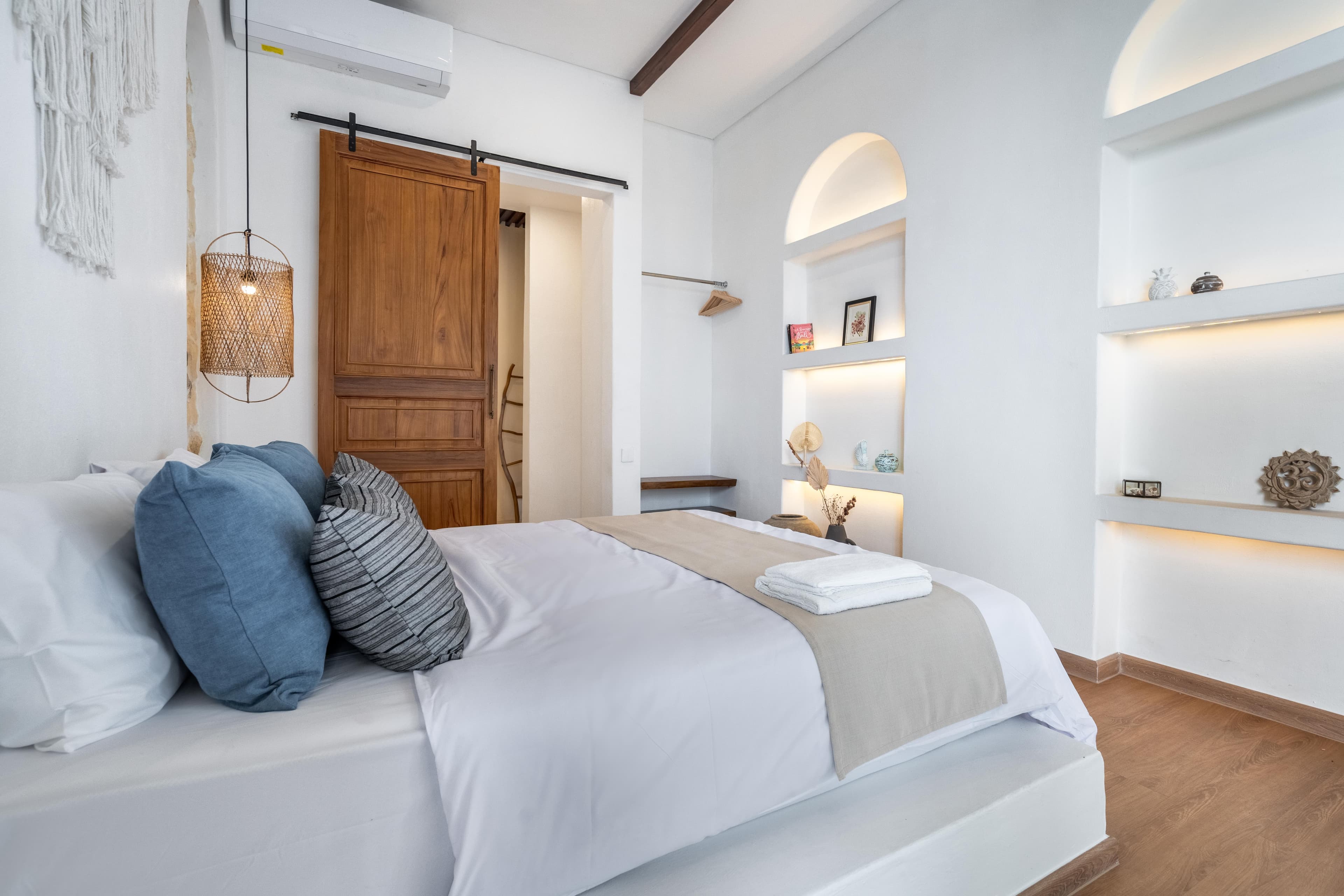 Palm Sugar Villa — bedroom with stone alcoves and macrame wall hanging